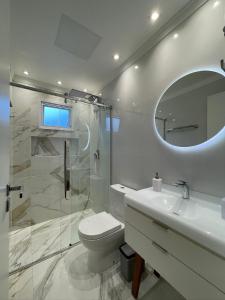 a bathroom with a toilet and a sink and a mirror at Dolce Vita in Porto Belo