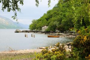 a boat in the water next to a mountain at Bains House, Gairloch in Gairloch +15 photos