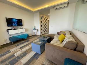 a living room with a couch and a tv at Jounieh Cozy Apartment with Sea View in Jounieh