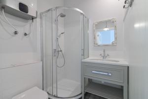 a white bathroom with a shower and a sink at Prawdziwa Jurata in Jurata +23 photos