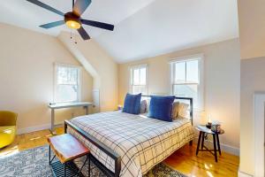 a bedroom with a bed with blue pillows and a ceiling fan at The Dinah Shore in Provincetown