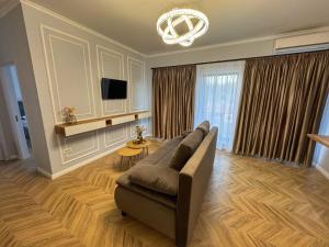 ein Wohnzimmer mit Sofa und Fernseher in der Unterkunft TisArt Accomodation in Tismana