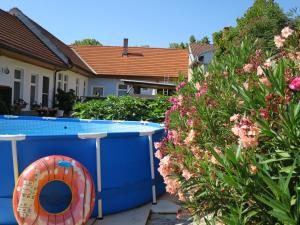 a swimming pool in a yard with pink flowers at Ferienwohnung 3 Ferienwohnungen Sattler in St. Andrä am Zicksee