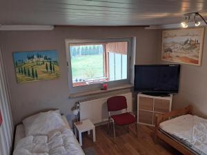 a small bedroom with a bed and a television at Neumünster 661 in Neumünster