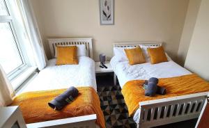 two beds in a room with two pillows at Ruby Retreat - Entire House - WiFi - 4 Bed - Garden in Maidstone