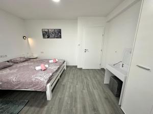 a bedroom with a bed and a desk and a sink at Apartman Zana in Visoko