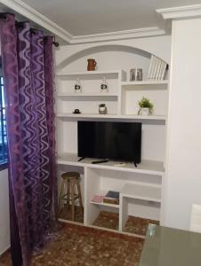 a living room with a tv on a shelf at Casa Paco in Linares