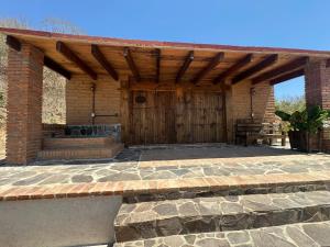 a patio with a wooden door and a bench at Casa Agave Huatulco in San Miguel