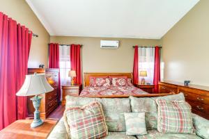 a bedroom with a bed and a couch and red curtains at 3 Mi Beech Mtn Resort: Cozy Studio w/ Deck & View! in Beech Mountain