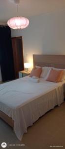 a bedroom with a large white bed with a pink light at Residencial Marilopez in Punta Cana