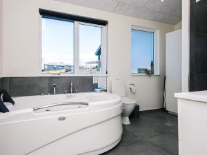 a white bathroom with a tub and a toilet at 5 star holiday home in Løgstrup in Løgstrup +78 photos
