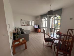 a living room with a table and a couch at Green Apartment 14 in Tavira Garden in Tavira