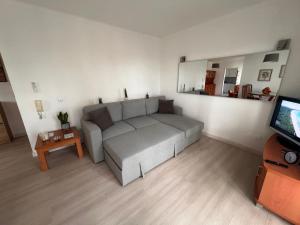 a living room with a couch and a television at Green Apartment 14 in Tavira Garden in Tavira