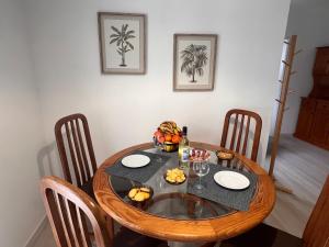 a wooden table with plates and fruit on it at Green Apartment 14 in Tavira Garden in Tavira