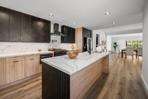 une cuisine avec des armoires en bois et un comptoir blanc dans l'établissement Tulum Style in Sherman Oaks, à Garnsey