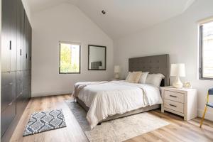 une chambre blanche avec un grand lit et un miroir dans l'établissement Tulum Style in Sherman Oaks, à Garnsey