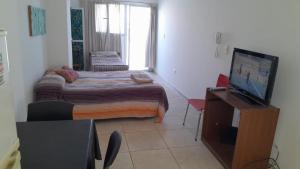 a small room with a bed and a television at Centro in Neuquén