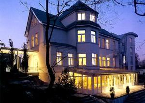 a large house with its lights on at night at Hotel Das Lola in Essen
