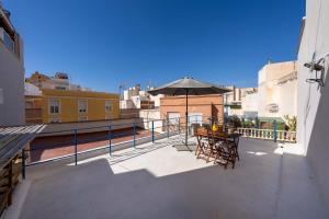 a patio with tables and an umbrella on a balcony at Casa Centro Histórico Almería - Jayrán in Almería
