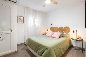 a white bedroom with a bed with a headboard at Casa Centro Histórico Almería - Jayrán in Almería