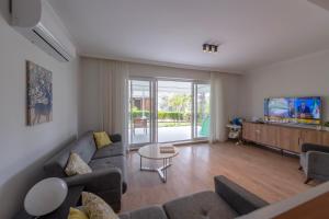 a living room with a couch and a tv at Palladium Villa in Side