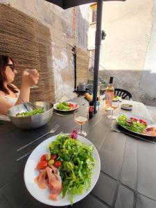 a woman sitting at a table with plates of food at Casa Bella - Borne arcade, Baby-Foot, Extérieur in Thiers +28 photos