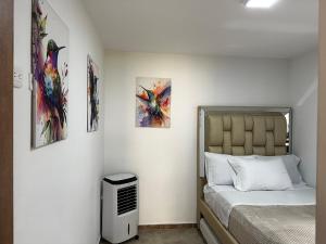 a bedroom with a bed and paintings on the wall at Villa edén La Tebaida Quindío in La Tebaida +13 photos