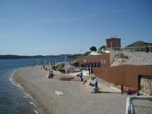 a group of people sitting on a beach next to the water at Apartment Boni in Šibenik