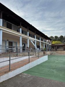 a building with a green field in front of it at Retiro Gastro-Rural - Habitaciones in Moratalla