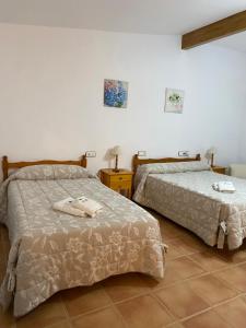 a bedroom with two beds and a table at Retiro Gastro-Rural - Habitaciones in Moratalla