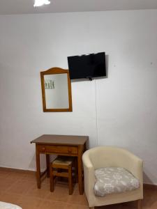 a chair and a desk with a mirror and a television at Retiro Gastro-Rural - Habitaciones in Moratalla