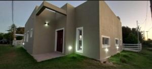 a small house with a large door in a yard at Casa de campo Ranchos in Ranchos