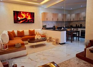 a living room with a couch and a kitchen at Azur Apartment essaouira in Essaouira