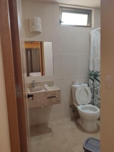 a bathroom with a toilet and a sink and a mirror at Tortuga Real Huatulco in Santa Cruz Huatulco