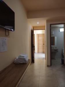 a room with a tv on the wall and a bathroom at Tortuga Real Huatulco in Santa Cruz Huatulco
