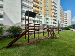 a park with a wooden playground in front of a building at Viva o Paraíso – Condomínio Exclusivo Beira-Mar e Lazer Completo in Ilha da Restinga