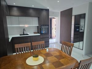 a kitchen with a wooden table and chairs and a kitchen with a sink at Apartmani Mikić in Bosanski Šamac