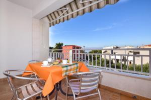 une salle à manger avec une table et des chaises sur un balcon dans l'établissement Apartments by the sea Tucepi, Makarska - 23944, à Tučepi