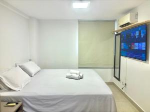 a room with a bed with two towels on it at Viva o Paraíso – Condomínio Exclusivo Beira-Mar e Lazer Completo in Ilha da Restinga