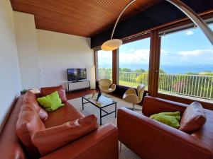 a living room with two couches and a large window at Evian villa with Lake Geneva views in 1960 mid-century modern style in Neuvecelle