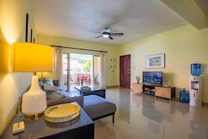 a living room with a couch and a tv at Pro Cab Paradise Condos Cabarete in Cabarete