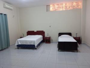 a room with two beds and a window at Casa Centrica in Yacuiba