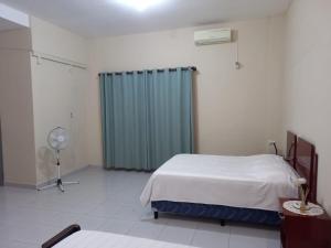 a bedroom with a bed and a green curtain at Casa Centrica in Yacuiba