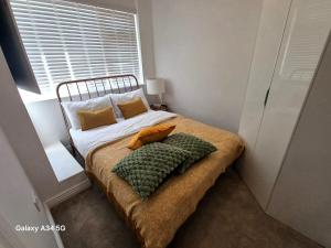 ein Bett mit zwei Kissen darauf in einem Schlafzimmer in der Unterkunft Luxurious 3 Bedroom House in Kent