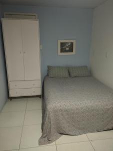 a small bedroom with a bed and a cabinet at Lumiar Garden Suítes e Chalés em Vilas do Atlântico in Lauro de Freitas