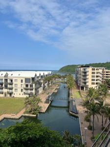 a body of water with buildings and palm trees at Ocean & Canal Views - The Sails Apartment in Durban +16 photos