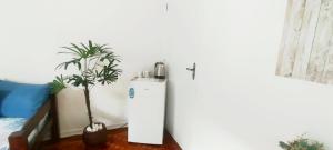グアルジャにあるQuarto Privativo Praia das Pitangueirasの植物のある部屋の中の白い冷蔵庫