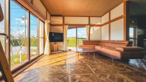 ein Wohnzimmer mit Couch und Fernseher in der Unterkunft 一棟貸切の和風プライベートヴィラ プール花火バーベキュー in Fukutsu