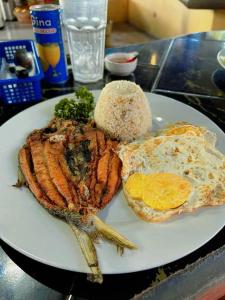 a plate of food with a breakfast of meat and eggs at Treasure Island Beach Resort in Olongapo