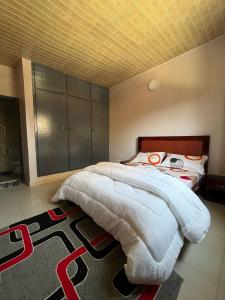 Un dormitorio con una cama grande en una habitación. en Le doux refuge, en Abiyán